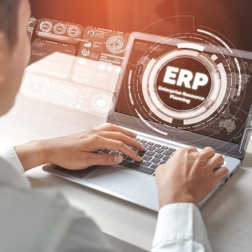 S/4HANA Core Finance Mann sitzt an Notebook auf dessen Screen "ERP" steht 